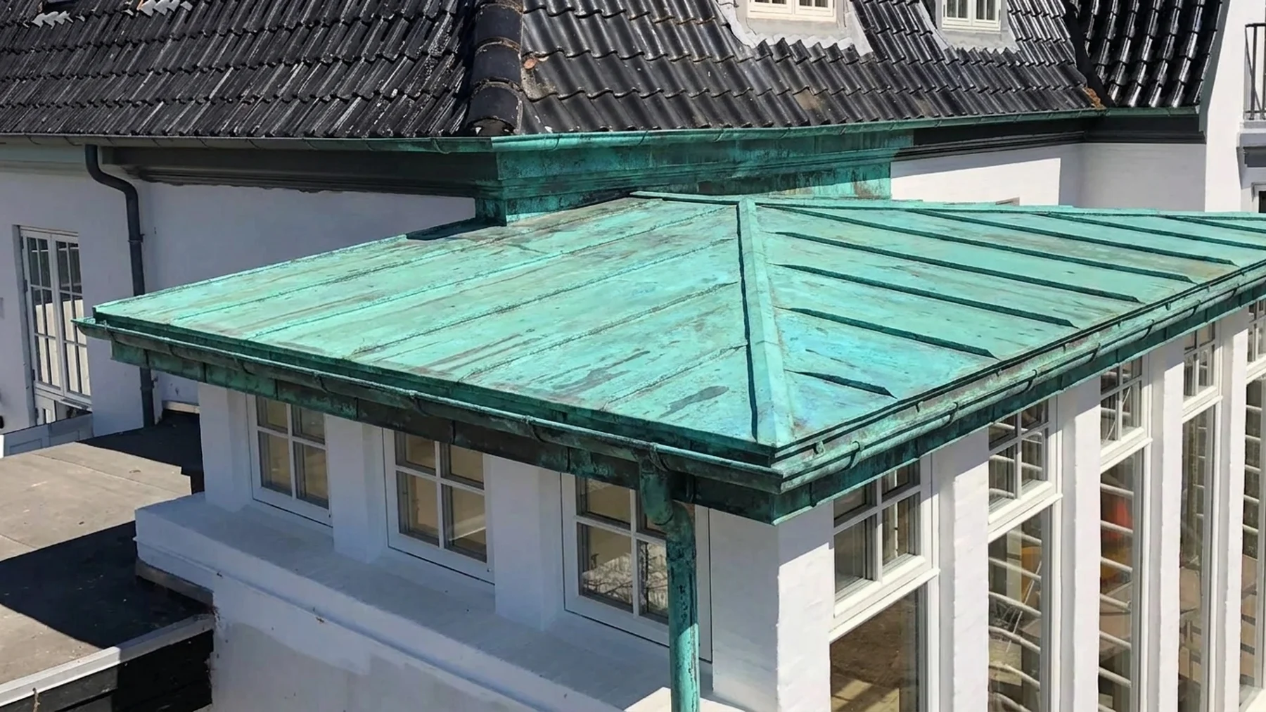 Samme kobbertag som øverst på siden, vist som det ser ud efter mange års vejr